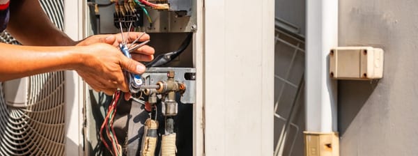 HVAC technician repairing an air conditioning unit